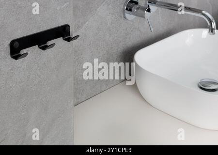 Bagno moderno con rubinetto cromato e ganci Foto Stock