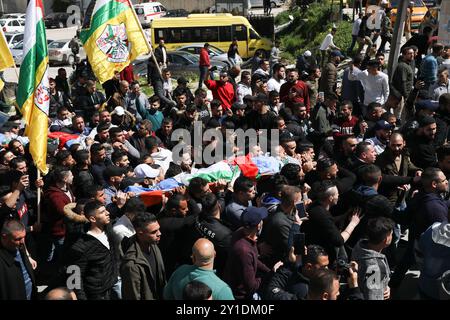 Nablus, Palestina, 20 marzo 2019. I lutti trasportano i corpi di Zaid Nuri, 20 anni, e Raed Hamdan, 21 anni, due uomini palestinesi uccisi dal fuoco vivo delle forze israeliane all'inizio di mercoledì nella zona di al-Ghawi, mentre le truppe israeliane scortavano centinaia di coloni a visitare la tomba di Giuseppe nella città di Nablus nella sponda occidentale settentrionale. Mentre le forze israeliane scortavano il convoglio di autobus di coloni ebrei nel sito, situato nell'area controllata dai palestinesi, i soldati israeliani aprirono il fuoco verso un veicolo in cui Hamdan e Nuri viaggiavano uccidendoli. L'esercito israeliano ha affermato che i due palestinesi presumibilmente Foto Stock