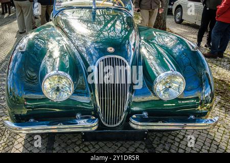 Lisbona, Portogallo - 20 gennaio 2024: Vista frontale della Jaguar XK120 Drop head coupé vintage verde scuro parcheggiata su una strada pavimentata in ciottoli. Roadster a due posti, auto sportiva, convertibile Foto Stock