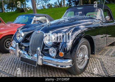 Lisbona, Portogallo - 20 gennaio 2024: Auto coupé vintage Jaguar XK150 verde scuro parcheggiata su una strada lastricata. Roadster a due posti, auto sportiva, convertibile Foto Stock