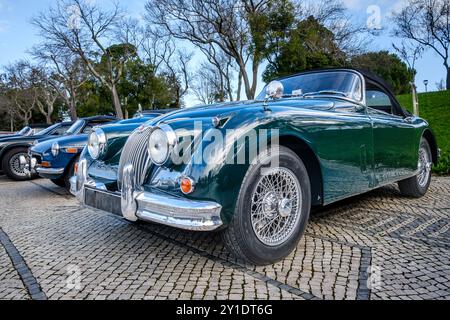 Lisbona, Portogallo - 20 gennaio 2024: Classica auto coupé Jaguar XK150 verde scuro parcheggiata su strade lastricate. Roadster a due posti, auto sportiva, convertibile Foto Stock