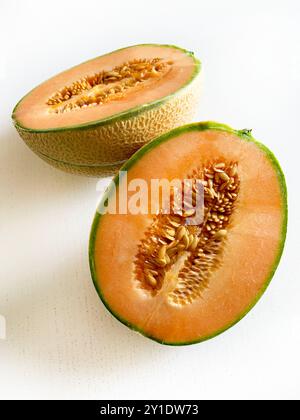 Melone Cantaloupe tagliato a metà isolato su sfondo bianco. Cibo sano e vegetariano. Direttamente sopra. Copia spazio. Foto Stock