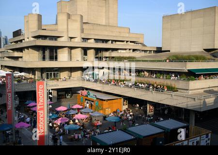 Persone che si godono un drink serale sulle terrazze del Teatro Nazionale. Il National Theatre fa parte del Southbank Centre. Il teatro era progettato Foto Stock