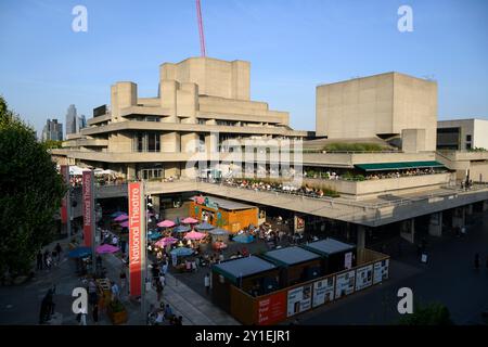 Persone che si godono un drink serale sulle terrazze del Teatro Nazionale. Il National Theatre fa parte del Southbank Centre. Il teatro era progettato Foto Stock