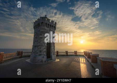 Vista al tramonto del faro di Piombino piazza Bovio e dell'Isola d'Elba sullo sfondo. Regione Toscana, Italia Foto Stock