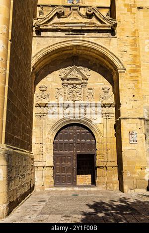 Ingresso principale alla maestosa Chiesa dell'assunzione, edificio in pietra gialla con archi, decorato con sculture. Briones, la Rioja, Spagna. Foto Stock