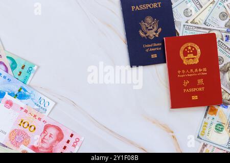 Passaporti autentici Cina e Stati Uniti con banconote cinesi in contanti yuan e dollari americani di vari tagli simboleggiano il confronto tra le economie Foto Stock