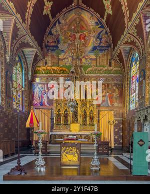 Bruges, Fiandre, Belgio - 25 giugno 2024: Basilica del Sacro sangue, altare maggiore e reredos dorati pieni di dipinti Foto Stock