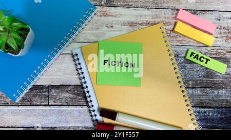 Concept of Fiction o Fact scrivere su appunti isolati su un tavolo di legno. Foto Stock