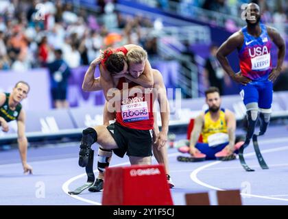 PARIGI, FRANCIA - 06 SETTEMBRE: Irmgard Bensusan della germania conforta i piani Johannes della germania (R) delusi dopo la classe T 62 di 400 m dei Giochi Paralimpici estivi di Parigi 2024 allo Stade de France il 6 settembre 2024 a Parigi, Francia. (Foto di Mika Volkmann) Foto Stock