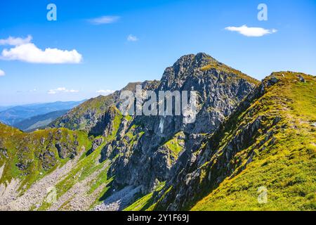 Il paesaggio mozzafiato del monte Dumbier rivela maestose formazioni rocciose sotto un cielo azzurro. Gli escursionisti possono godere di viste mozzafiato dei Low Tatra in questa popolare destinazione all'aperto. Foto Stock