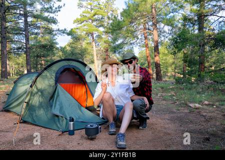 Coppia, tenda e selfie da campeggio con sorriso, memoria e vacanza, blog web e mattinata in campagna. Uomo, donna e relax con le vacanze, i social media Foto Stock