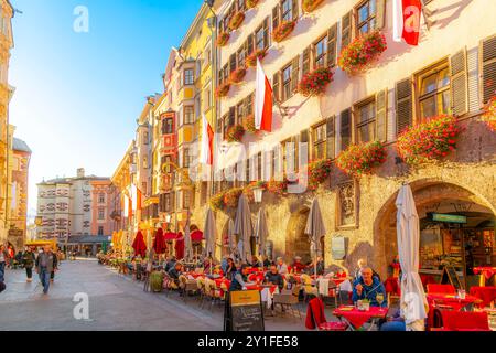 Una strada acciottolata di caffetterie e negozi sul marciapiede nel quartiere storico della città Vecchia di Innsbruck, Austria. Foto Stock