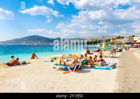 Persone che prendono il sole alla spiaggia Okrug Gornji, isola di Ciovo sul mare Adriatico vicino a Traù, Croazia Foto Stock