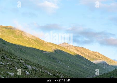 Le pendici illuminate dal sole dell'altopiano di Amaklit a Camlihemsin, con rocce aspre e vegetazione lussureggiante, offrono una vista mozzafiato della natura incontaminata e del tranqu Foto Stock