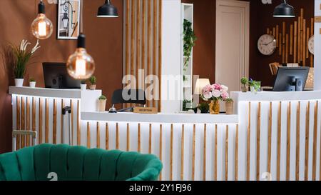 Reception dell'hotel costosa con banco ricevimento vuoto e moderno, area lounge con mobili lussuosi ed elegante banco di registrazione. Elegante rifugio di vacanza con splendido design degli interni. Foto Stock
