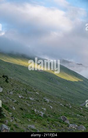 Le pendici illuminate dal sole dell'altopiano di Amaklit a Camlihemsin, con rocce aspre e vegetazione lussureggiante, offrono una vista mozzafiato della natura incontaminata e del tranqu Foto Stock