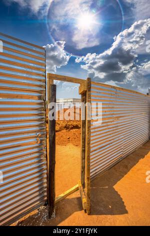 ingresso al cantiere, recinzione in fogli di ferro ondulato Foto Stock