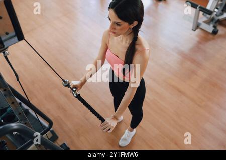 Il peso si sposta sulla macchina mentre Una donna si allena Foto Stock