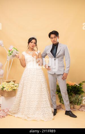 elegante coppia maschile e femminile in pose formali in piedi rilassata sorridente guardando l'un l'altro intimamente in interni. matrimonio di coppia Foto Stock