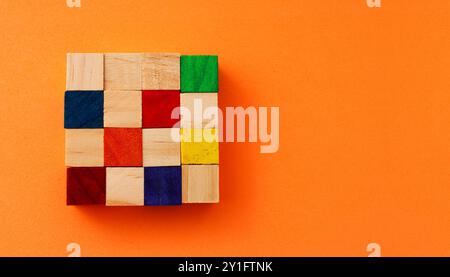 Cubi di legno di diversi colori, tra gli altri, senza colore che formano un'area quadrata Foto Stock