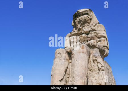 Ammira i maestosi Colossi di Memnone mentre si stagliano con orgoglio nella luce soffusa del mattino. Queste colossali statue gemelle del faraone Amenofi III hanno Foto Stock