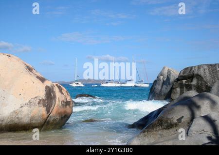 Virgin Gorda, Isole Vergini britanniche - 27 febbraio 2006: Una vista dei bellissimi massi e delle formazioni rocciose delle Terme. Le barche a vela sono ancorate Foto Stock