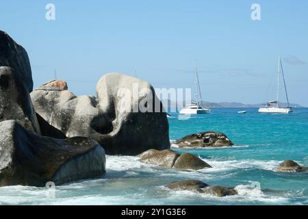 Virgin Gorda, Isole Vergini britanniche - 27 febbraio 2006: Una vista dei bellissimi massi e delle formazioni rocciose delle Terme. Le barche a vela sono ancorate Foto Stock