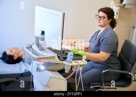 Il dipendente della clinica sul posto di lavoro esegue una diagnosi ecografica Foto Stock