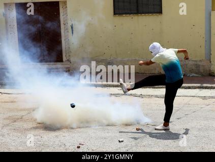 I manifestanti palestinesi si scontrano con le forze di sicurezza israeliane nella città di Kafr Qaddum in Cisgiordania mentre l'esercito israeliano cerca di reprimere la loro manifestazione settimanale contro il muro di separazione israeliano, la confisca della loro terra, il vicino insediamento israeliano di Kadumin e la chiusura nel 2003 della strada principale della città. La strada è stata chiusa ai palestinesi dopo l'espansione dell'insediamento israeliano di Kedumin, limitando seriamente i loro spostamenti intorno alla loro città e aumentando drasticamente il tempo di viaggio verso la città di Nablus, che è il principale centro economico più vicino Foto Stock