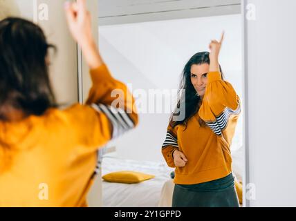 Una donna single sicura di sé che punta il dito al riflesso nello specchio che balla e abbatte bene. Una persona indipendente con un'alta autostima parla positivo Foto Stock