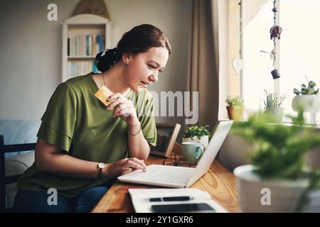 Lavoro da remoto, carta di credito o donna al computer portatile per consegna di cibo, shopping online o sconti. A casa, scrittore o libero professionista nel fintech banking Foto Stock