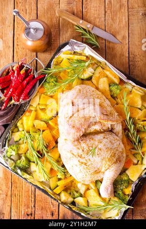 Il pollo crudo con prezzemolo e le patate in una teglia da forno Foto Stock