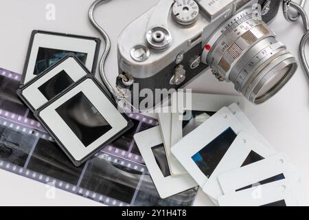 Una classica fotocamera vintage con negativi e diapositive in pellicola fotografica isolati in bianco. Foto Stock