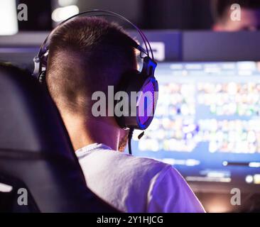 Torneo di eSports il giocatore in cuffia gioca a videogame PC computer club strategia in tempo reale multiplayer competizione online. Abilità. Cyber spo Foto Stock