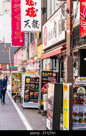 Ammira i numerosi ristoranti, tra cui uno Yakiniku e un ristorante italiano, sulla strada nel quartiere a luci rosse di Kabukicho a Shinjuku. Foto Stock