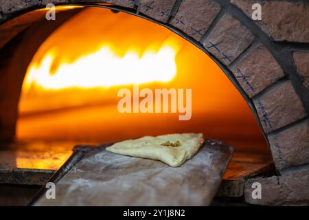 Forno in pietra mediorientale vecchio stile. Cibo libanese Manakish cotto nel forno a pietra Foto Stock