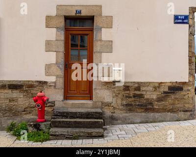 Una porta di una vecchia casa su una strada con un idrante vicino, situata a Lannion, Bretagna, Francia. Foto Stock
