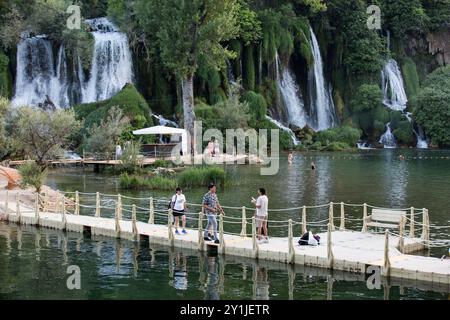 12 giugno 2024, Studenci, Erzegovina occidentale, Bosnia ed Erzegovina: La gente cammina vicino alle cascate di Kravica. Le cascate di Kravica sono uno dei siti naturali più belli della regione di Herzegovinian in Bosnia. La cascata è alta circa 25 metri e divisa in 20 cascate, con il lago sottostante di circa 120 metri di raggio. Kravica è una famosa area per nuotare e fare picnic ed è una meta turistica attraente. (Immagine di credito: © Karol Serewis/SOPA Images via ZUMA Press Wire) SOLO PER USO EDITORIALE! Non per USO commerciale! Foto Stock