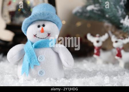 Divertente personaggio di pupazzo di neve e decorazioni natalizie sulla neve artificiale Foto Stock
