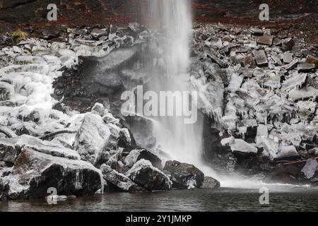 Le rocce alla base dell'Hardraw Force, la cascata più alta d'Inghilterra, sono ricoperte di ghiaccio in una giornata invernale innevata a dicembre Foto Stock