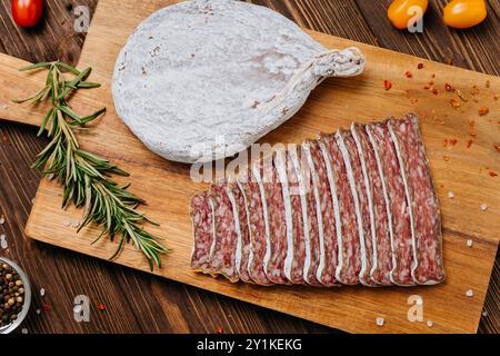 Primo piano di salame salato a fette a bordo, ideale per piatti gourmet e presentazioni di salumi Foto Stock