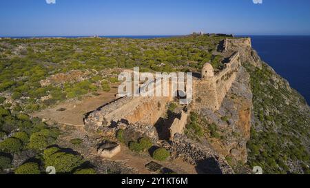 Colpo di droni, un'antica fortezza in rovina che corre lungo una scogliera sovrastata sul mare, fortezza marina veneziana, Gramvoussa, penisola di Gramvoussa, Pi Foto Stock