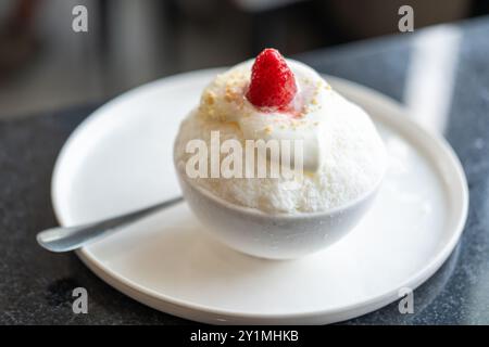 Ghiaccio rasato o Bingsu con fragola sopra, servito in una ciotola Foto Stock