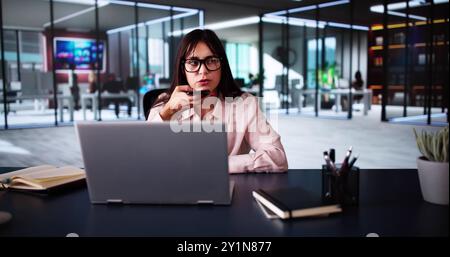 Venditrice sorridente che effettua Una chiamata aziendale su smartphone nell'ufficio moderno come operatore di telemarketing Foto Stock