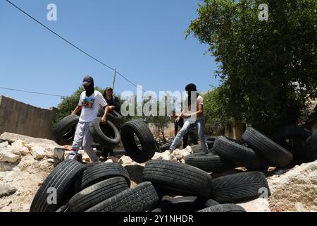 Qalqilia, Palestina. 5 luglio 2019. I manifestanti palestinesi si scontrano con i soldati israeliani nella città della Cisgiordania di Kafr Qaddum durante la loro protesta settimanale del venerdì contro gli insediamenti israeliani illegali. Alcuni palestinesi hanno bruciato pneumatici e lanciato pietre contro le forze israeliane che hanno sparato gas lacrimogeni e proiettili rivestiti di gomma ai manifestanti ferendone almeno quattro. Dal luglio 2011, i residenti di Kafr Qaddum e dei villaggi limitrofi organizzano proteste il venerdì contro l’estensione del vicino insediamento israeliano di Qadumim, la chiusura ai palestinesi della strada principale del villaggio e il Foto Stock