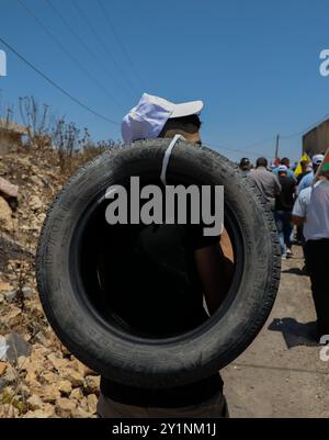 Qalqilia, Palestina. 5 luglio 2019. I manifestanti palestinesi si scontrano con i soldati israeliani nella città della Cisgiordania di Kafr Qaddum durante la loro protesta settimanale del venerdì contro gli insediamenti israeliani illegali. Alcuni palestinesi hanno bruciato pneumatici e lanciato pietre contro le forze israeliane che hanno sparato gas lacrimogeni e proiettili rivestiti di gomma ai manifestanti ferendone almeno quattro. Dal luglio 2011, i residenti di Kafr Qaddum e dei villaggi limitrofi organizzano proteste il venerdì contro l’estensione del vicino insediamento israeliano di Qadumim, la chiusura ai palestinesi della strada principale del villaggio e il Foto Stock