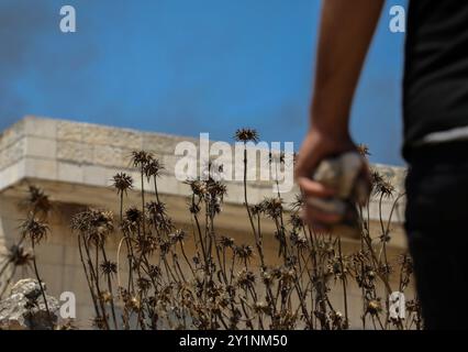 Qalqilia, Palestina. 5 luglio 2019. I manifestanti palestinesi si scontrano con i soldati israeliani nella città della Cisgiordania di Kafr Qaddum durante la loro protesta settimanale del venerdì contro gli insediamenti israeliani illegali. Alcuni palestinesi hanno bruciato pneumatici e lanciato pietre contro le forze israeliane che hanno sparato gas lacrimogeni e proiettili rivestiti di gomma ai manifestanti ferendone almeno quattro. Dal luglio 2011, i residenti di Kafr Qaddum e dei villaggi limitrofi organizzano proteste il venerdì contro l’estensione del vicino insediamento israeliano di Qadumim, la chiusura ai palestinesi della strada principale del villaggio e il Foto Stock