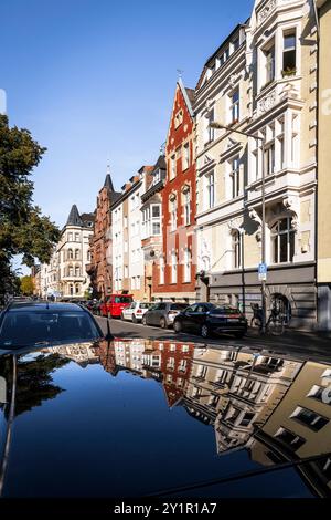 Le case della Spichernstreet si riflettono nel tetto di un'auto, Colonia, Germania. Gruenderzeitbauten in der Spichernstrasse spiegeln sich in einem Autodach, Foto Stock