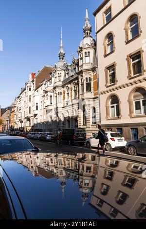 Le case della Spichernstreet si riflettono nel tetto di un'auto, Colonia, Germania. Gruenderzeitbauten in der Spichernstrasse spiegeln sich in einem Autodach, Foto Stock